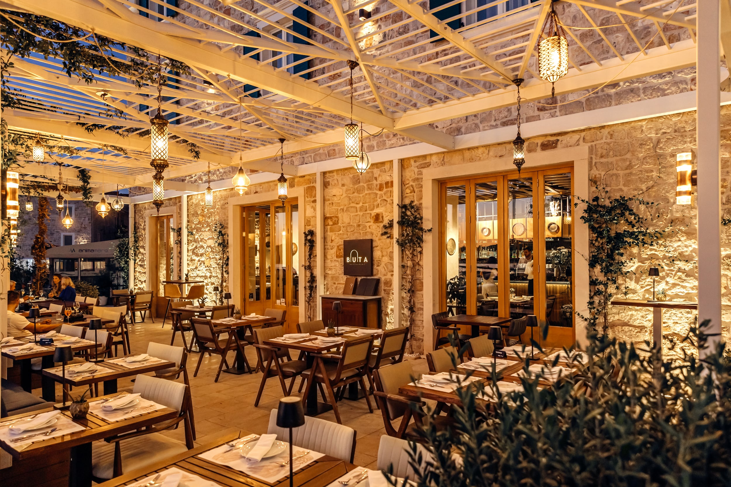 Buta dining room with warm lighting and tables prepared for service.