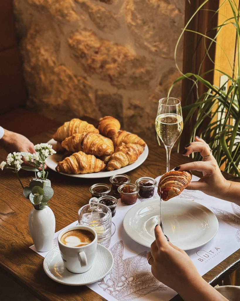 Croissants with preserves and coffee on the breakfast table.