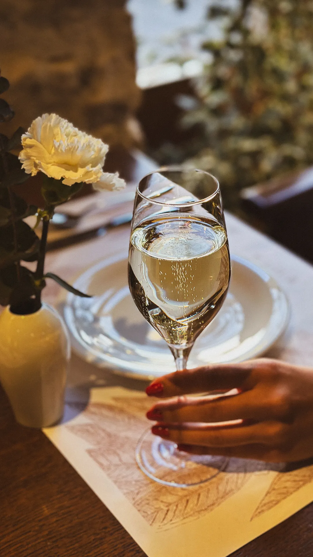 Čaša bijelog vina za stolom restorana A Bar & Restaurant.